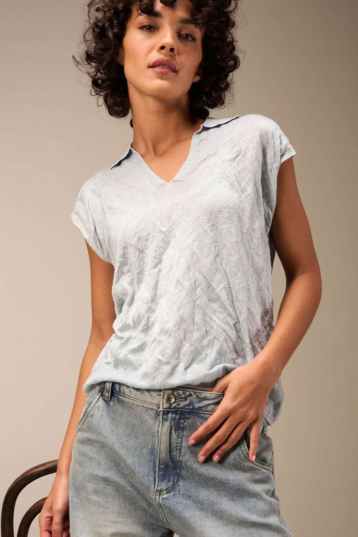 Veste légère à manches courtes et col en V, style décontracté, portée avec un pantalon en denim.