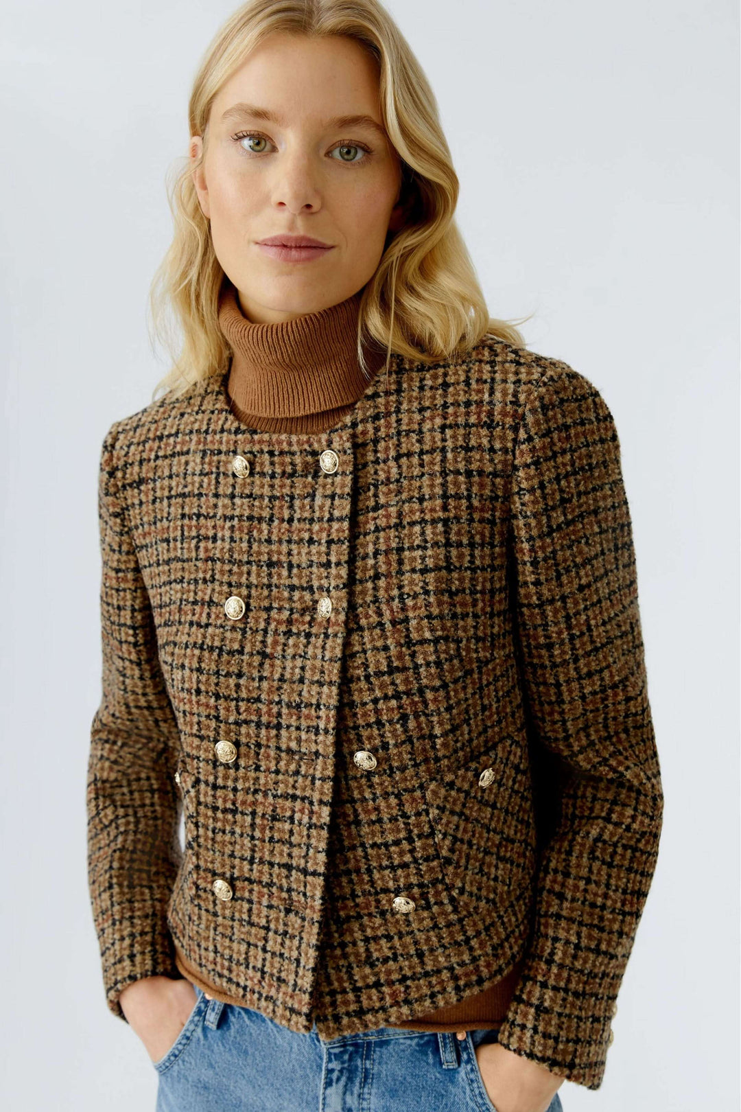 Veste courte à carreaux, boutons dorés en lainage texturé, élégante et intemporelle, portée avec un col roulé et un jean.