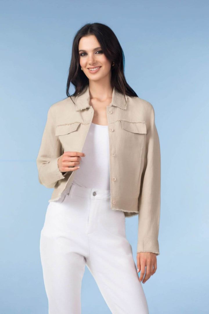 Femme portant une veste courte à finitions effilochées beige, silhouettée moderne et naturelle, complétant une tenue élégante.