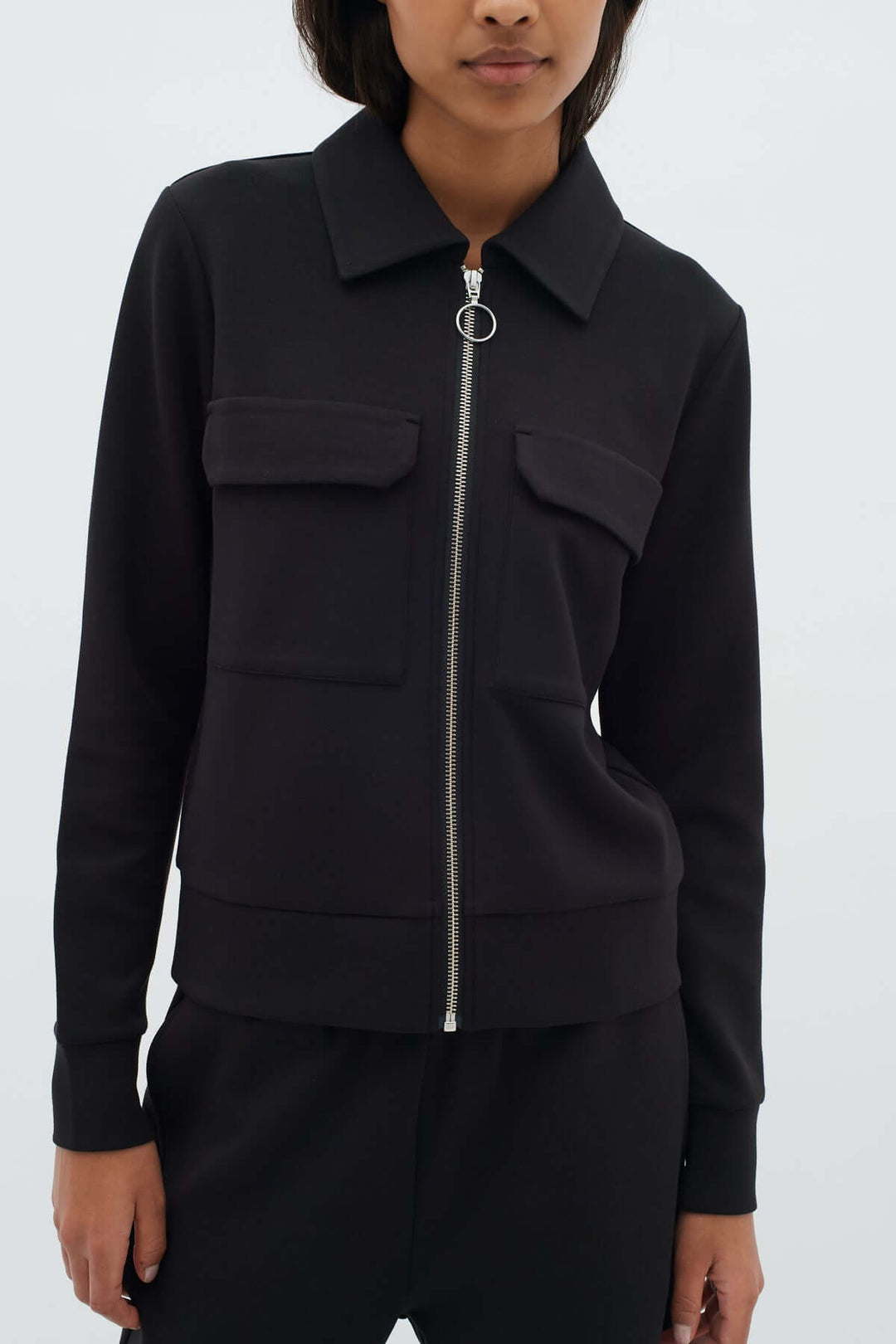 Veste courte zippée Beca noire avec fermeture éclair, coupe moderne et structurée, idéale pour un look casual ou élégant.