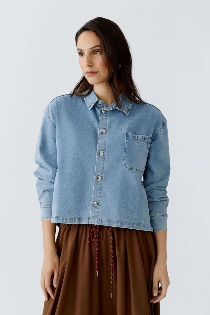 Femme portant une veste en denim moderne à coupe droite et ample, idéale pour un style décontracté et quotidien.