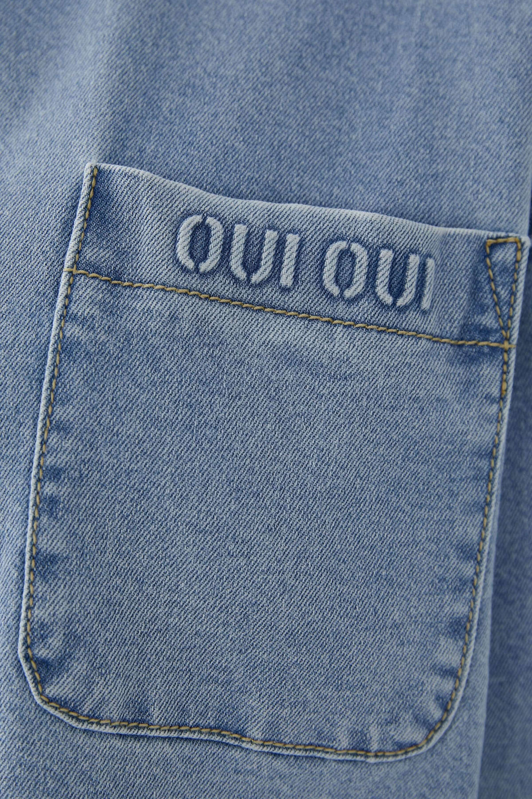 Détail de poche de la veste en denim avec broderie &