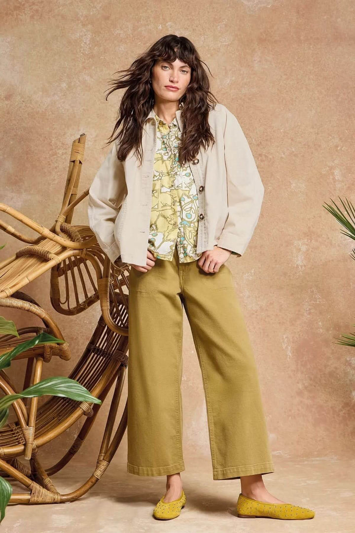 Femme portant une veste en denim Eden à col sur chemise imprimée avec un pantalon large dans un décor bohème.