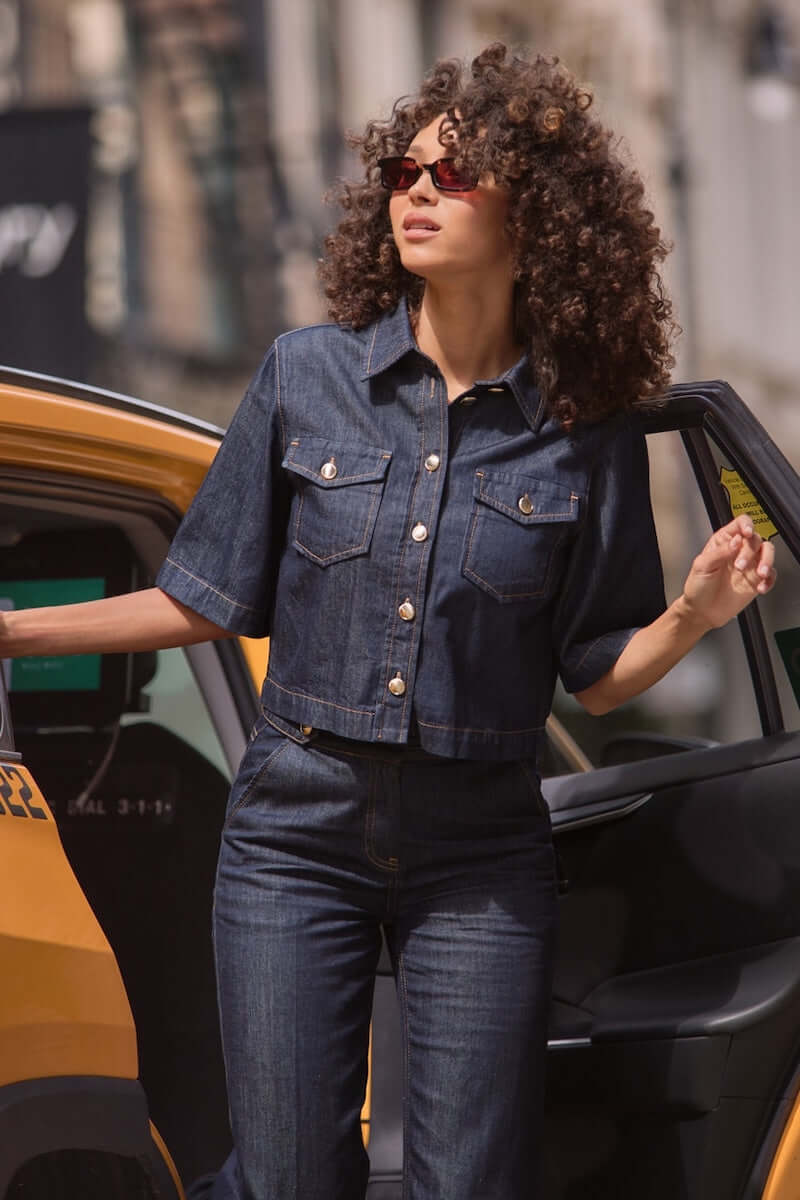Femme portant une veste en jeans courte avec manches évasées, sortant d&