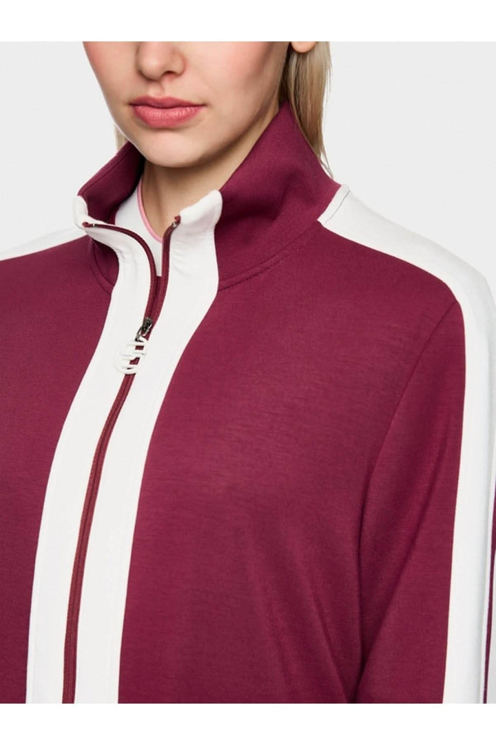 Veste en jersey ample avec col montant et fermeture éclair logo Marc Cain, détail bandes contrastées bordeaux et blanches.