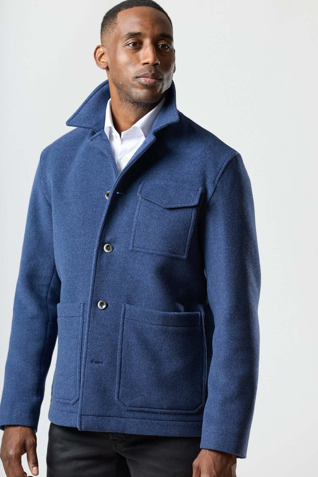 Veste en laine à poches plaquées en bleu avec grandes poches plaquées et col relevé, portée par un modèle sur fond neutre.