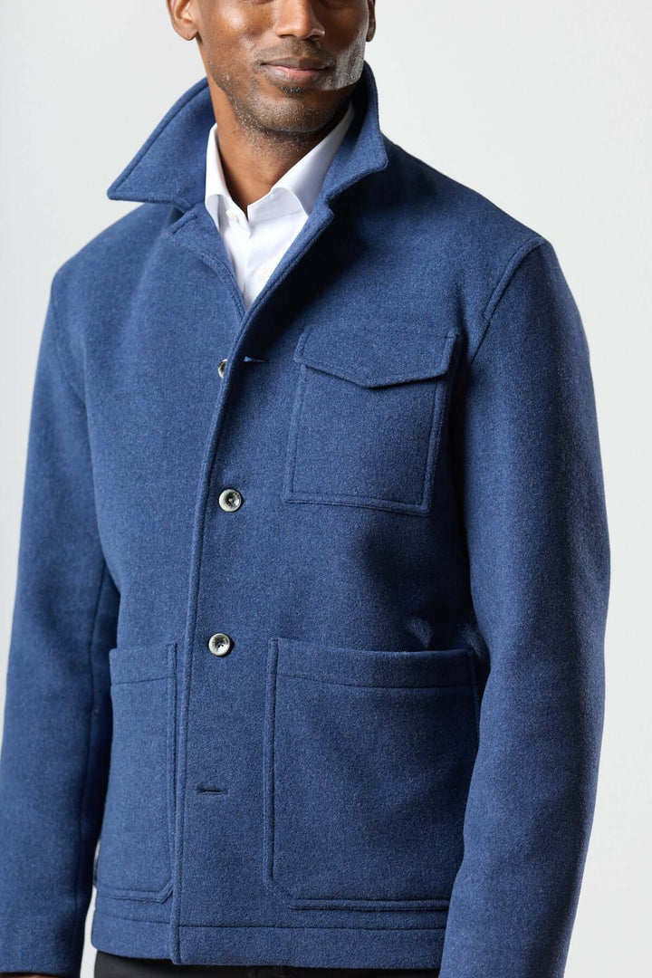 Homme portant une veste en laine à poches plaquées, coupe droite, avec col et poches de style workwear.