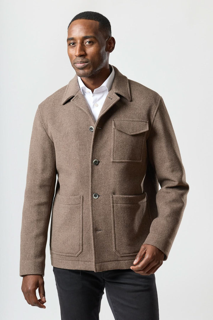 Homme portant une Veste en laine à poches plaquées sur une chemise blanche, style structuré et élégant pour le bureau.