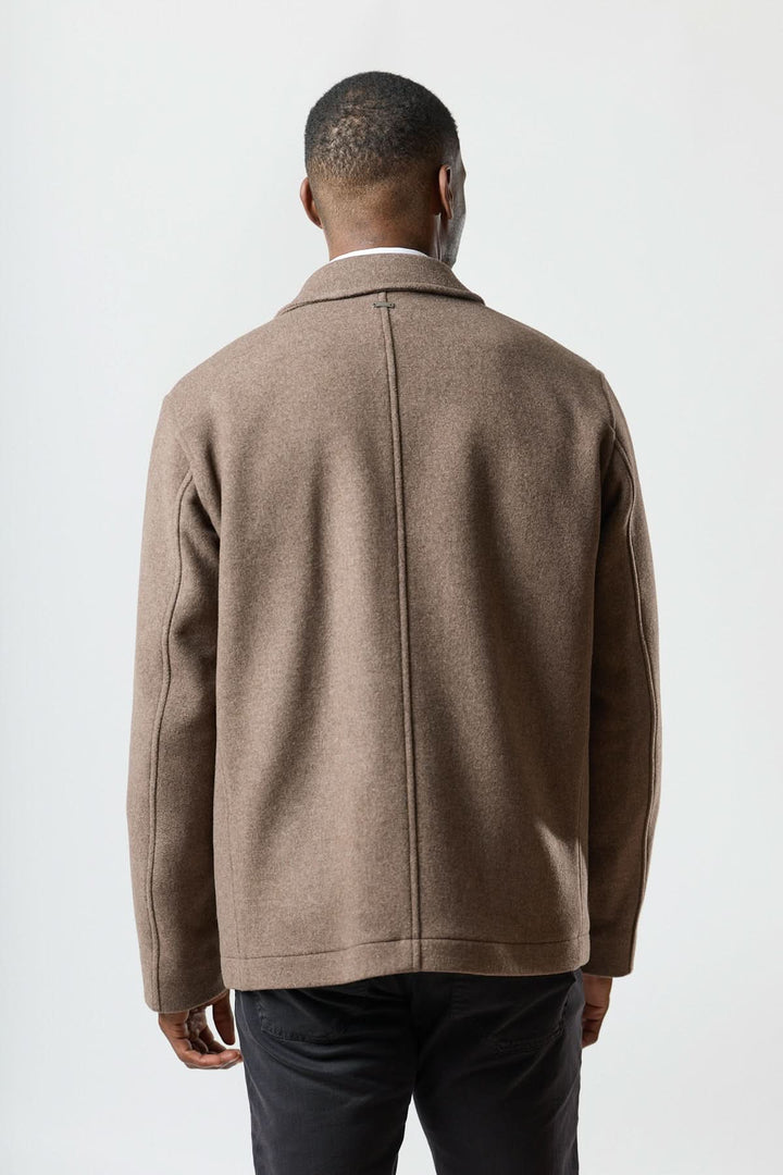 Homme portant une veste en laine à poches plaquées, coupe droite et élégante, vu de dos pour un style chic et polyvalent.