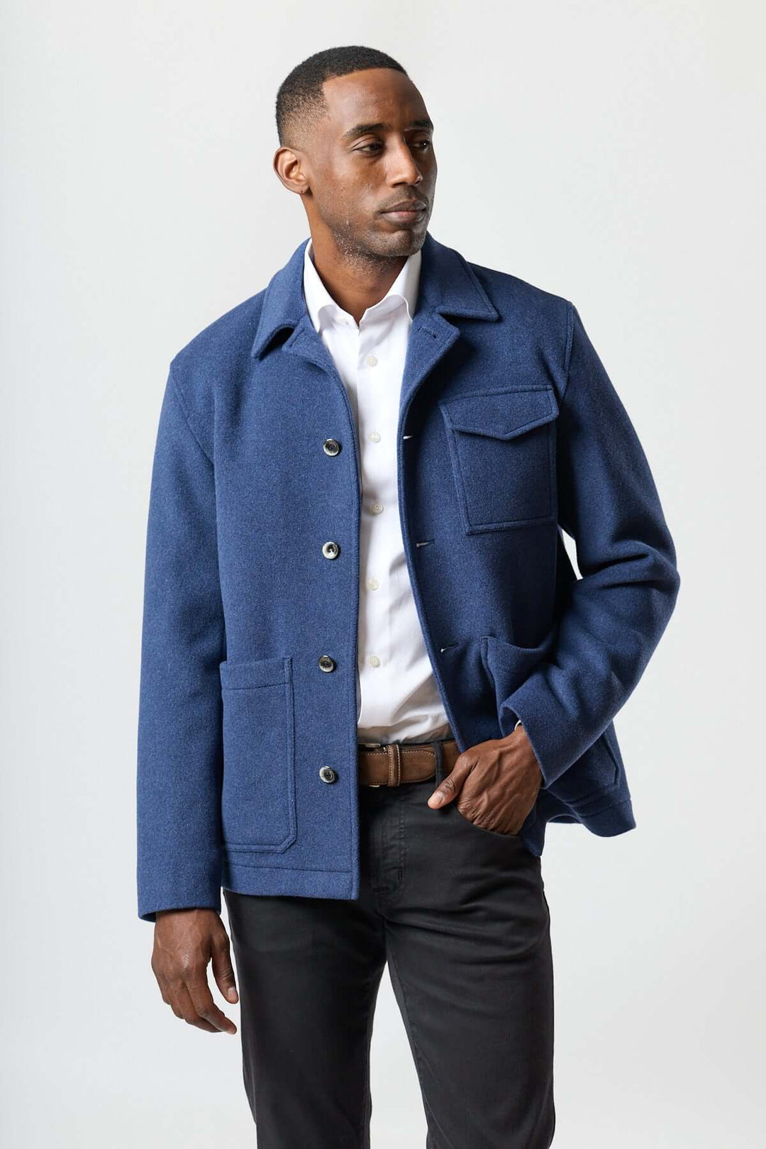Homme portant une veste en laine à poches plaquées bleue, coupe droite, idéale pour le bureau ou le week-end.