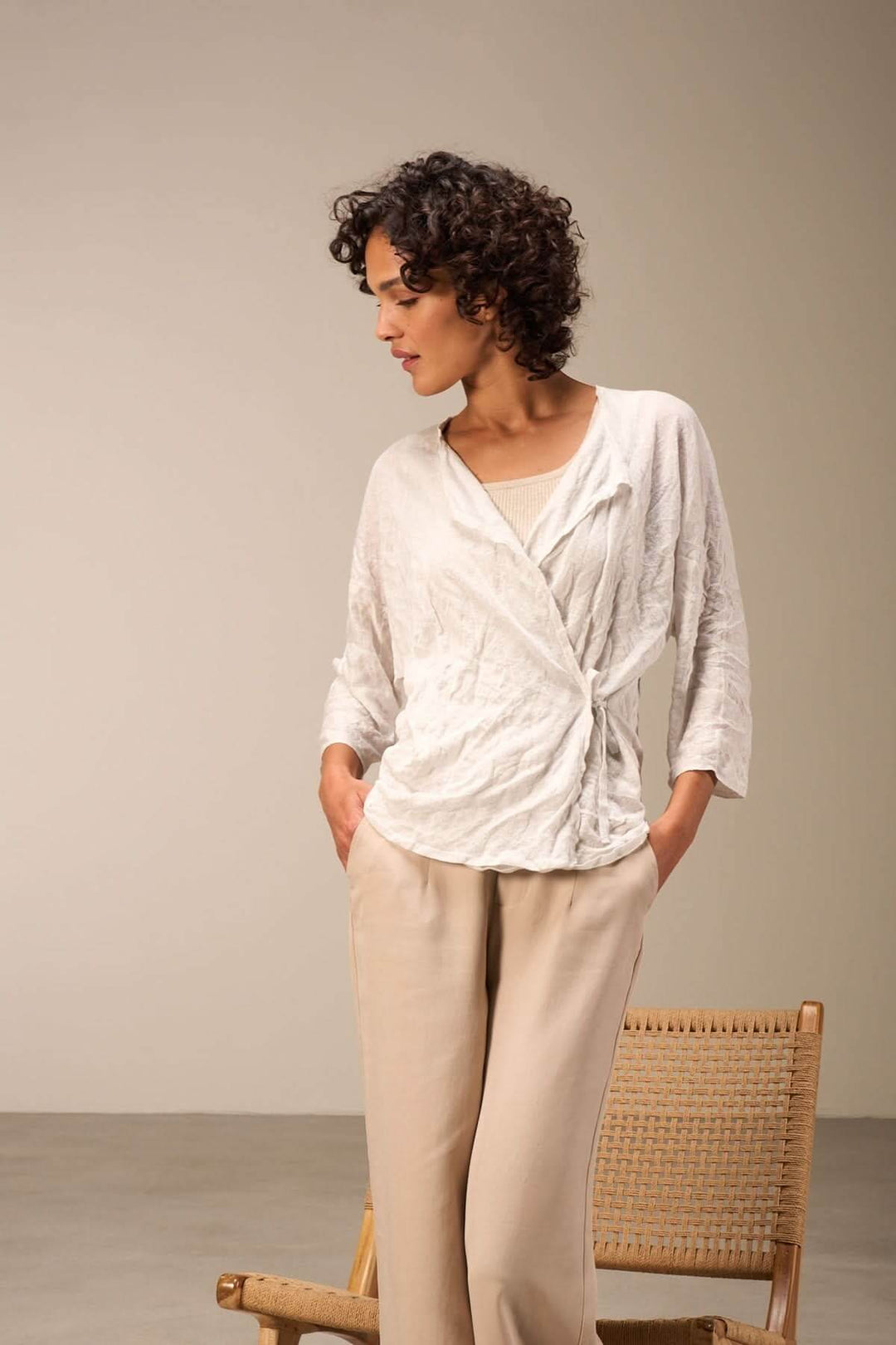 Femme portant une veste en tissu léger, couleur blanche, avec manches trois-quarts, look chic décontracté.