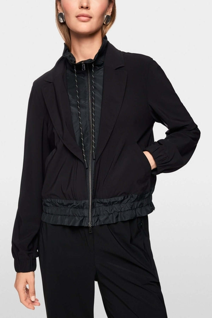 Veste légère noire avec col à revers, poignets élastiques et fermeture éclair, alliant style sportif et élégant.