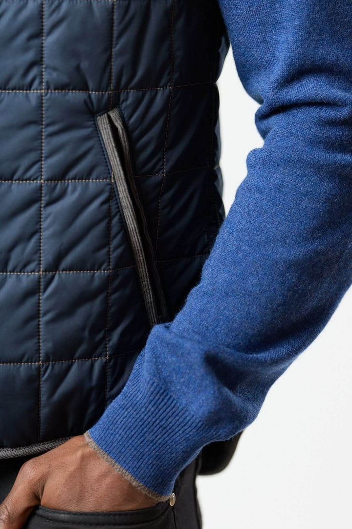 Veste sans manches matelassée avec détails en velours côtelé, montrant une grande qualité de finition et élégance.