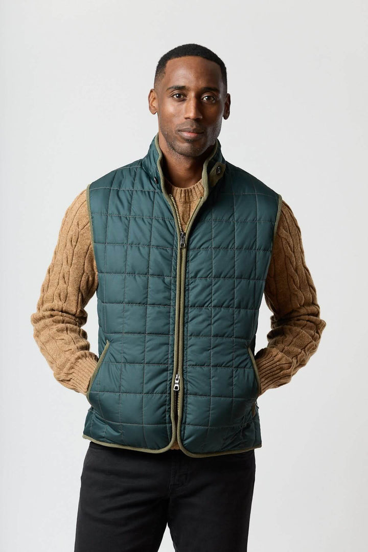 Homme portant une Veste sans manches matelassée avec détails en velours côtelé, combinant style et praticité.