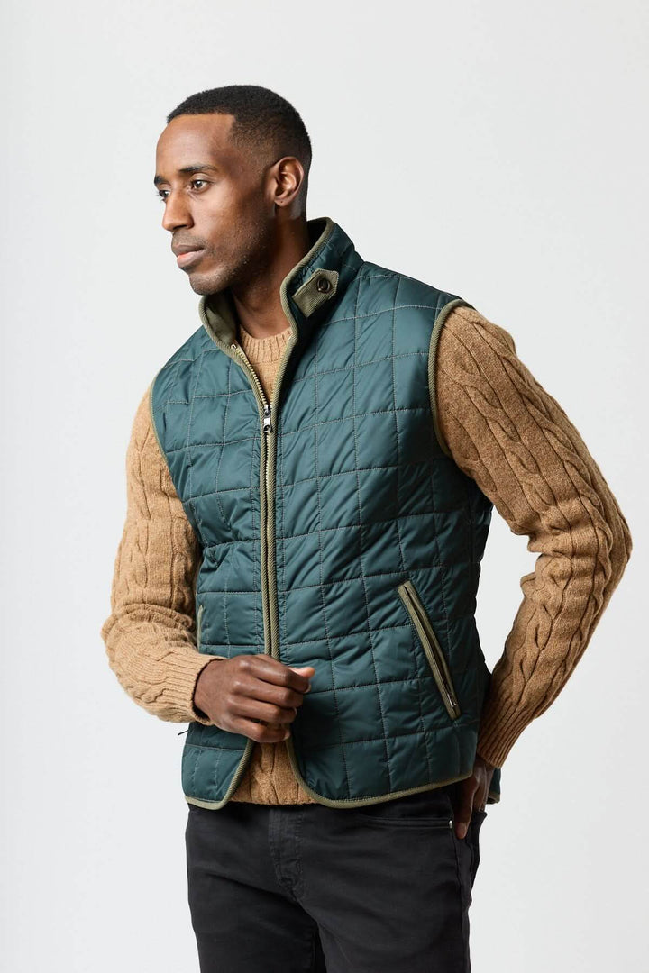 Homme portant une Veste sans manches matelassée avec détails en velours côtelé, élégante et pratique pour une tenue sophistiquée.