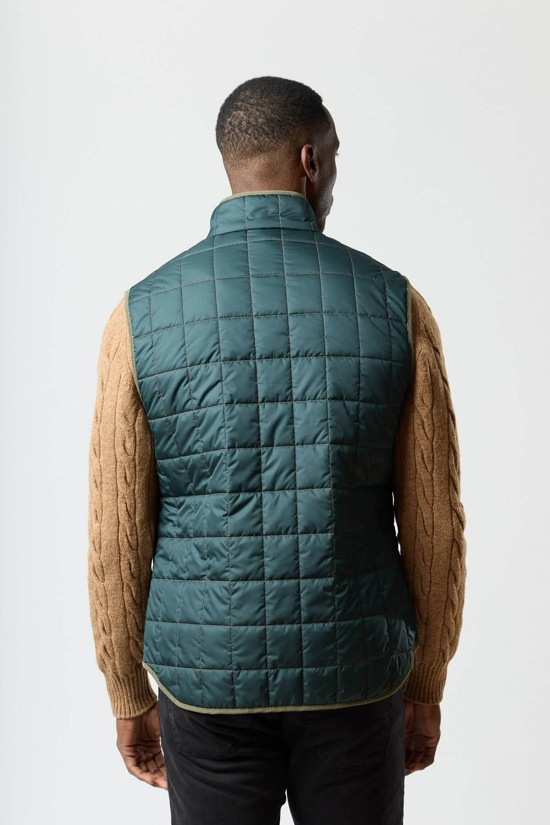 Homme portant une veste sans manches matelassée avec détails en velours côtelé, vue arrière, idéal pour style raffiné et pratique.
