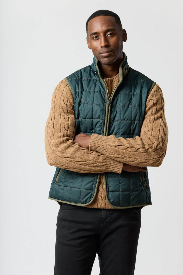 Veste sans manches matelassée avec détails en velours côtelé portée par un homme, combinant style et praticité.