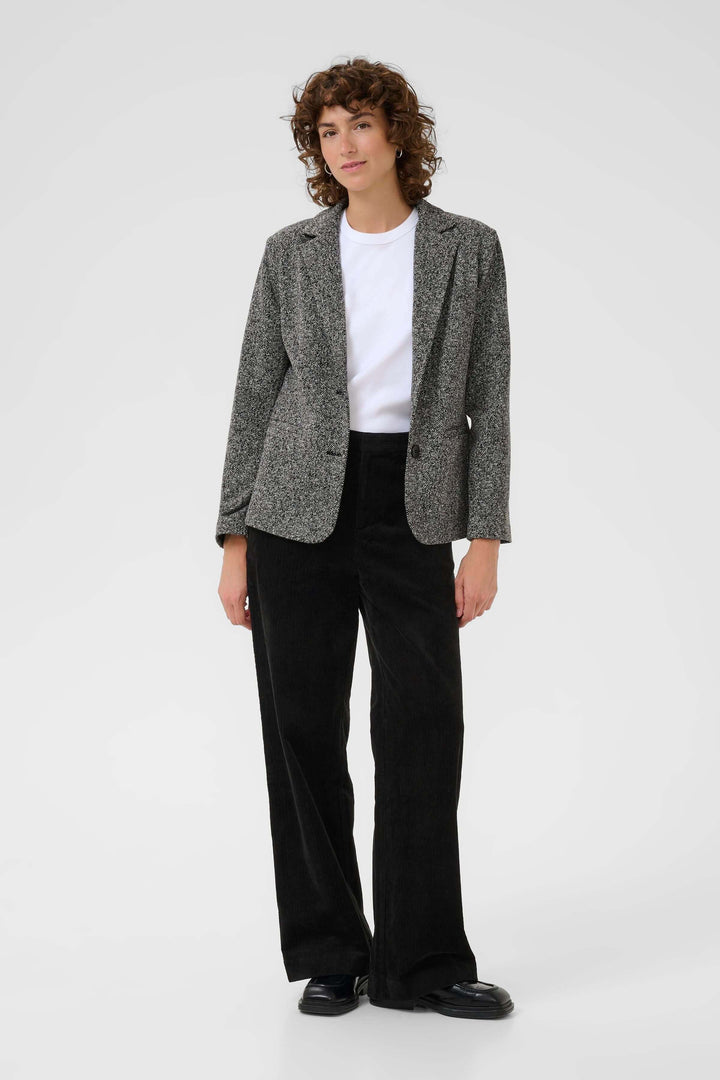 Veston Vineke femme, style structuré avec tissu texturé et fermeture un bouton, porté pour un look moderne et polyvalent.