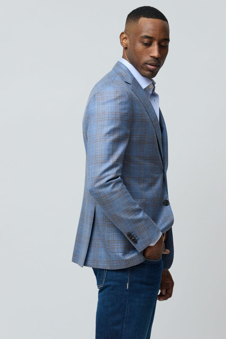 Homme portant un veston à carreaux en laine, soie et lin, coupe ajustée avec motif subtil, idéale pour un style décontracté chic.