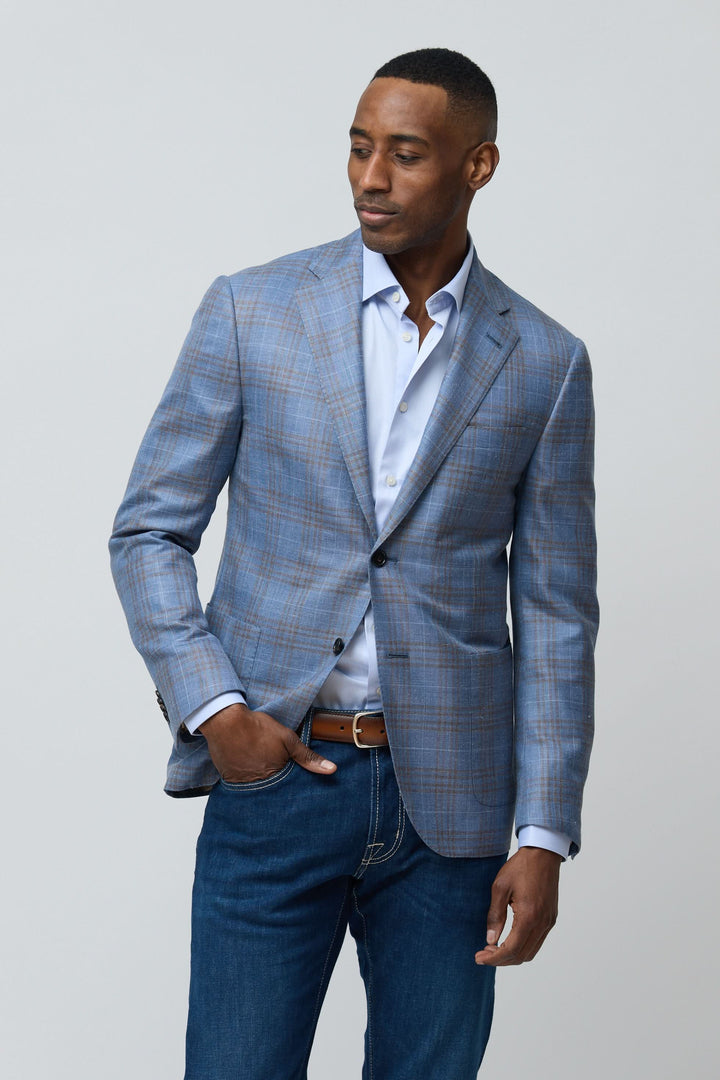 Veston à carreaux en laine, soie et lin porté sur chemise bleu clair et jeans