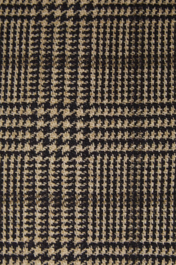 Texture of a classic houndstooth pattern in black and beige woven fabric, ideal for tailoring and fashion.