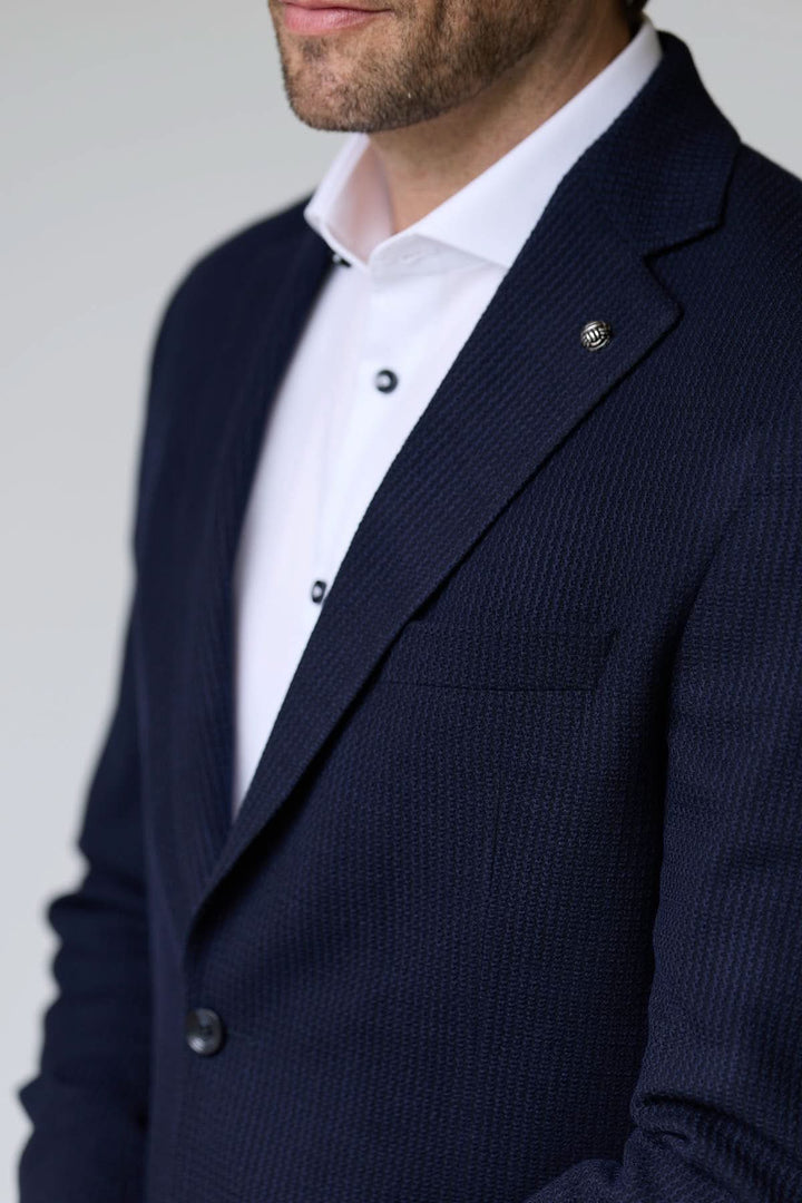 Veston en tricot structuré avec coupe semi-ajustée, pour un style élégant et décontracté, idéal sur chemise ou t-shirt blanc.