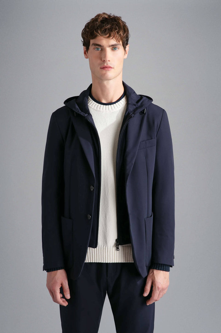 Homme portant un veston extensible à capuchon, alliant style contemporain et confort.