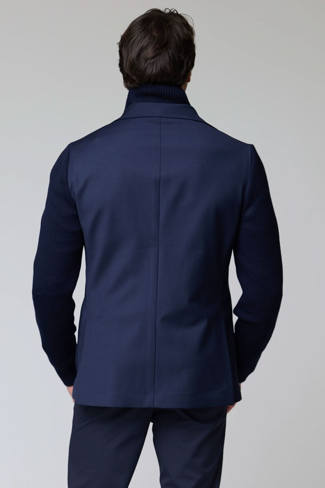 Veston hybride tricot et tissu vu de dos, manches en tricot, col à revers classique, style chic et décontracté.