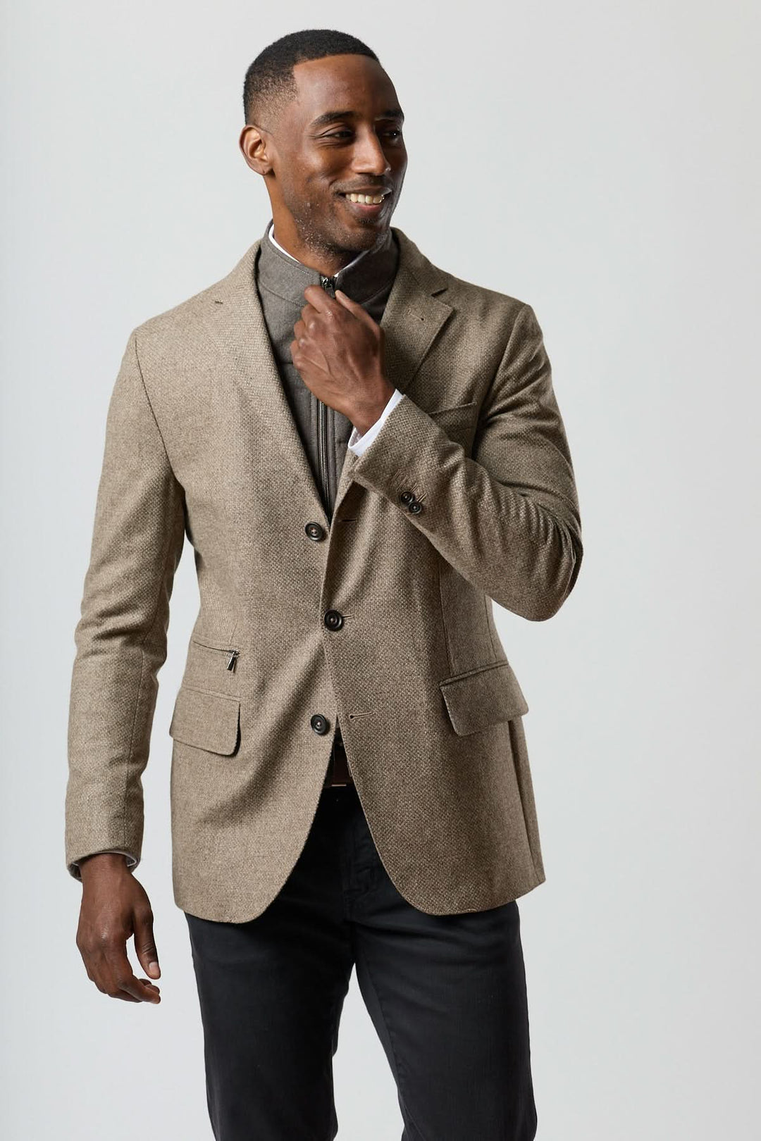 Veston texturé en laine avec col amovible intégré en beige doré, porté par un homme élégant pour un style contemporain.