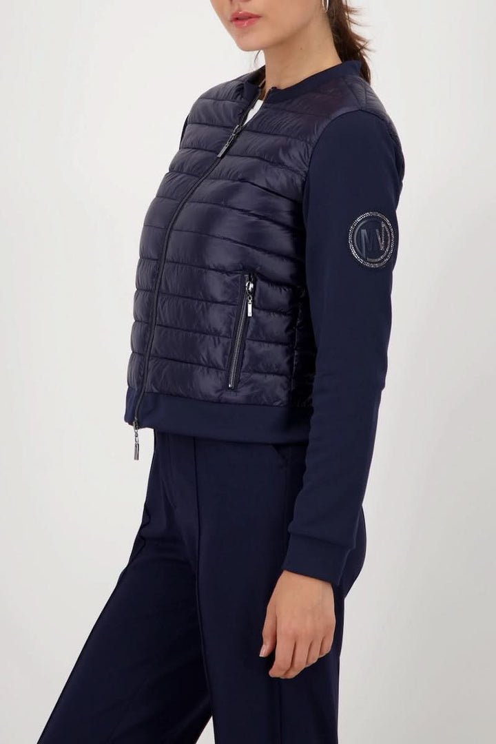 Veste matelassée bimatière à fermeture éclair avec manches souples, poches zippées, et style moderne et chic en vue latérale.