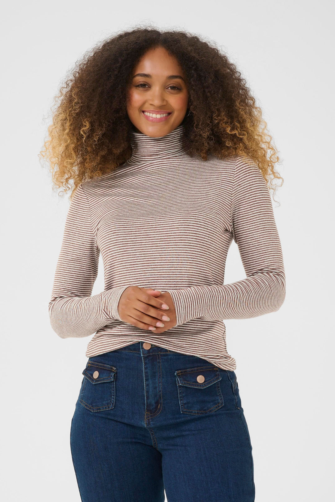 Femme portant le Chandail Amma à col roulé rayé ajusté, confortable et tendance pour un look moderne et décontracté.