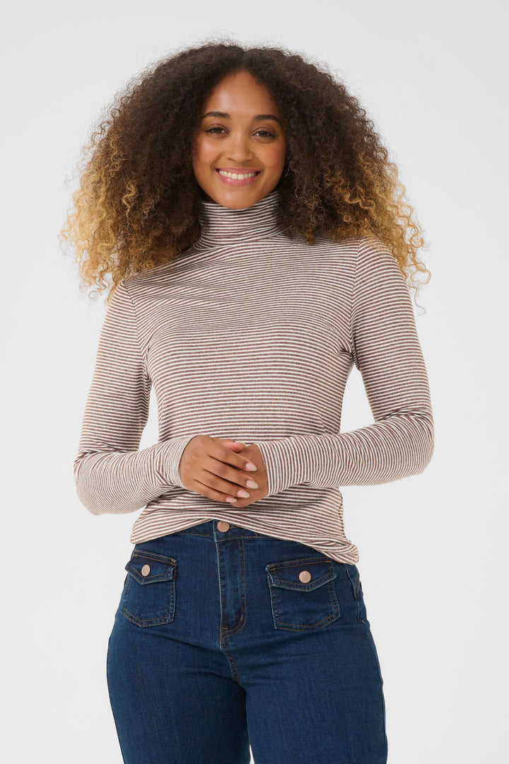 Femme portant le Chandail Amma à col roulé rayé ajusté, confortable et tendance pour un look moderne et décontracté.