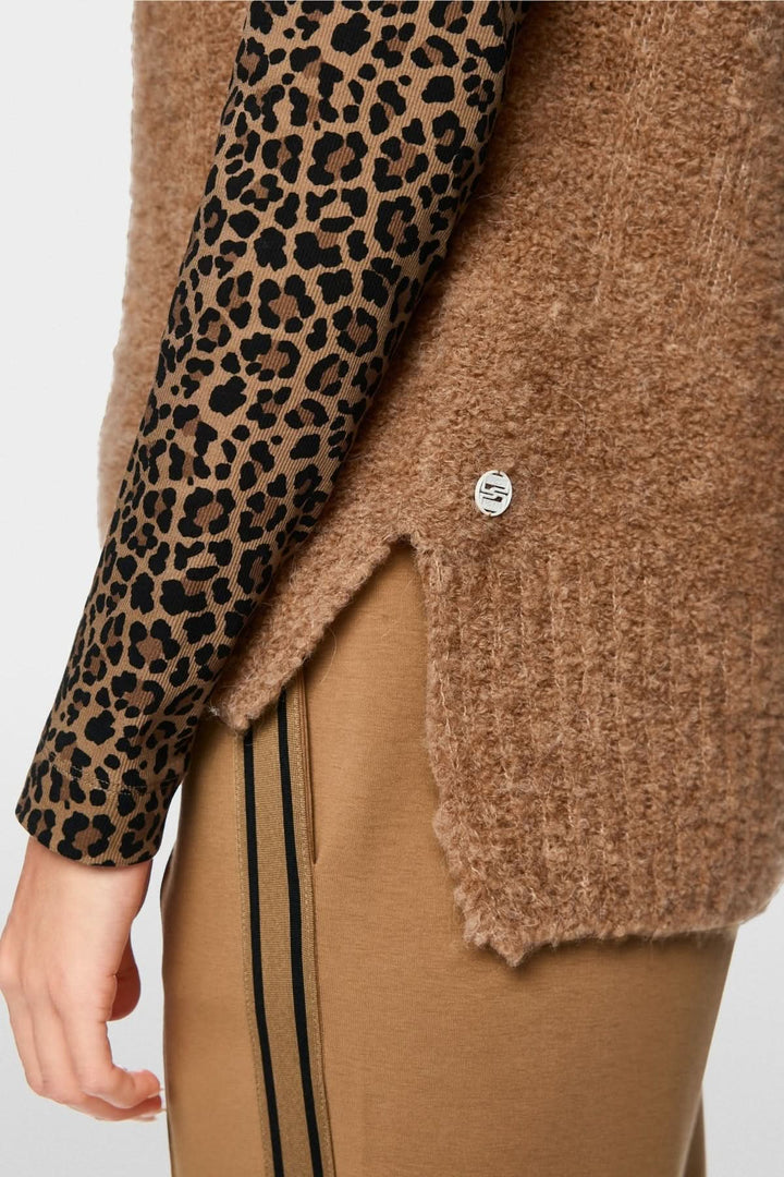 Veste sans manche tricoté avec col chemise et texture moelleuse, portée sur chemise à motif animal pour style moderne.