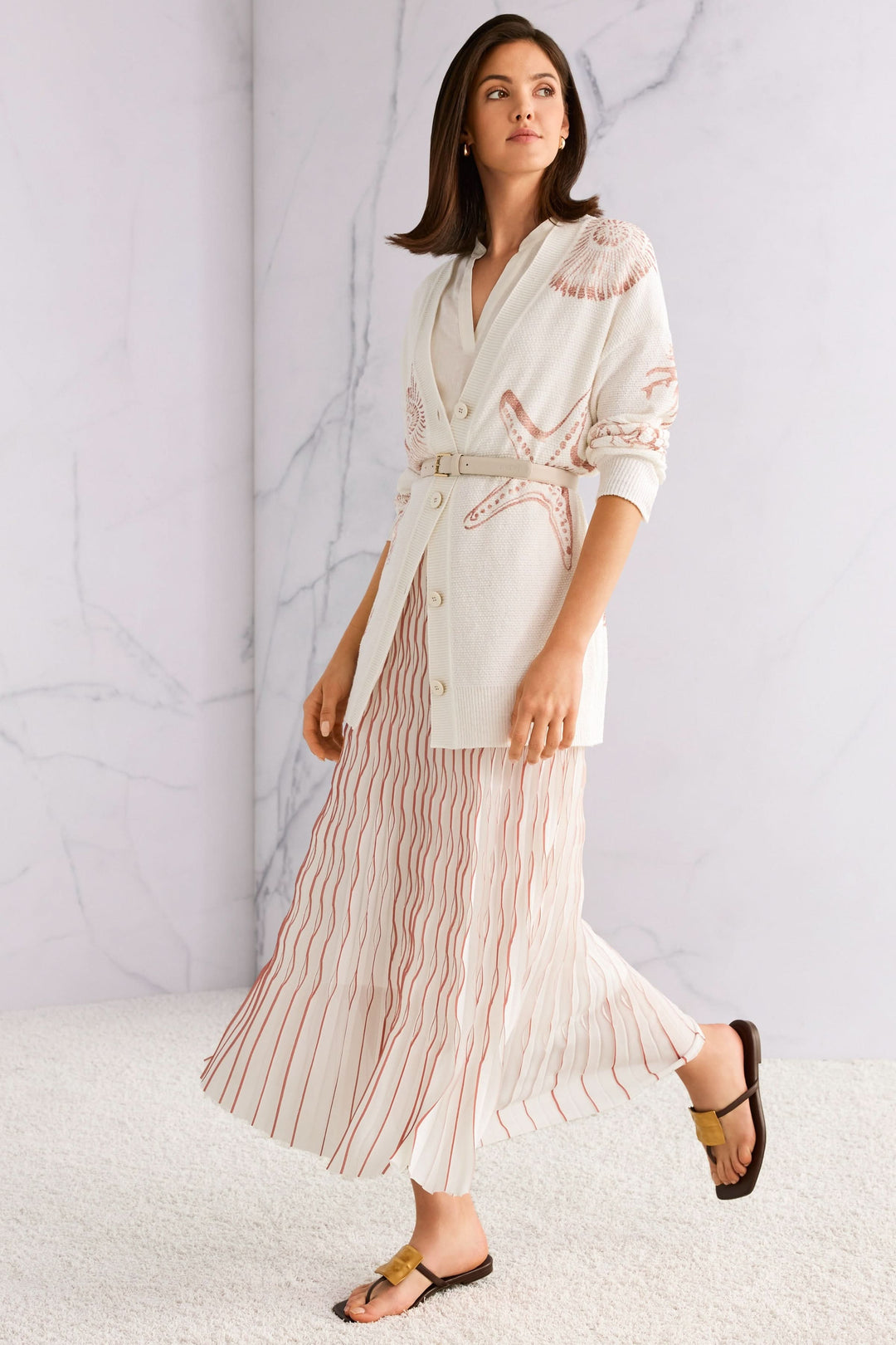 Modèle portant une jupe longue plissée avec mouvement et élégance, taille élastique pour un look féminin et raffiné.