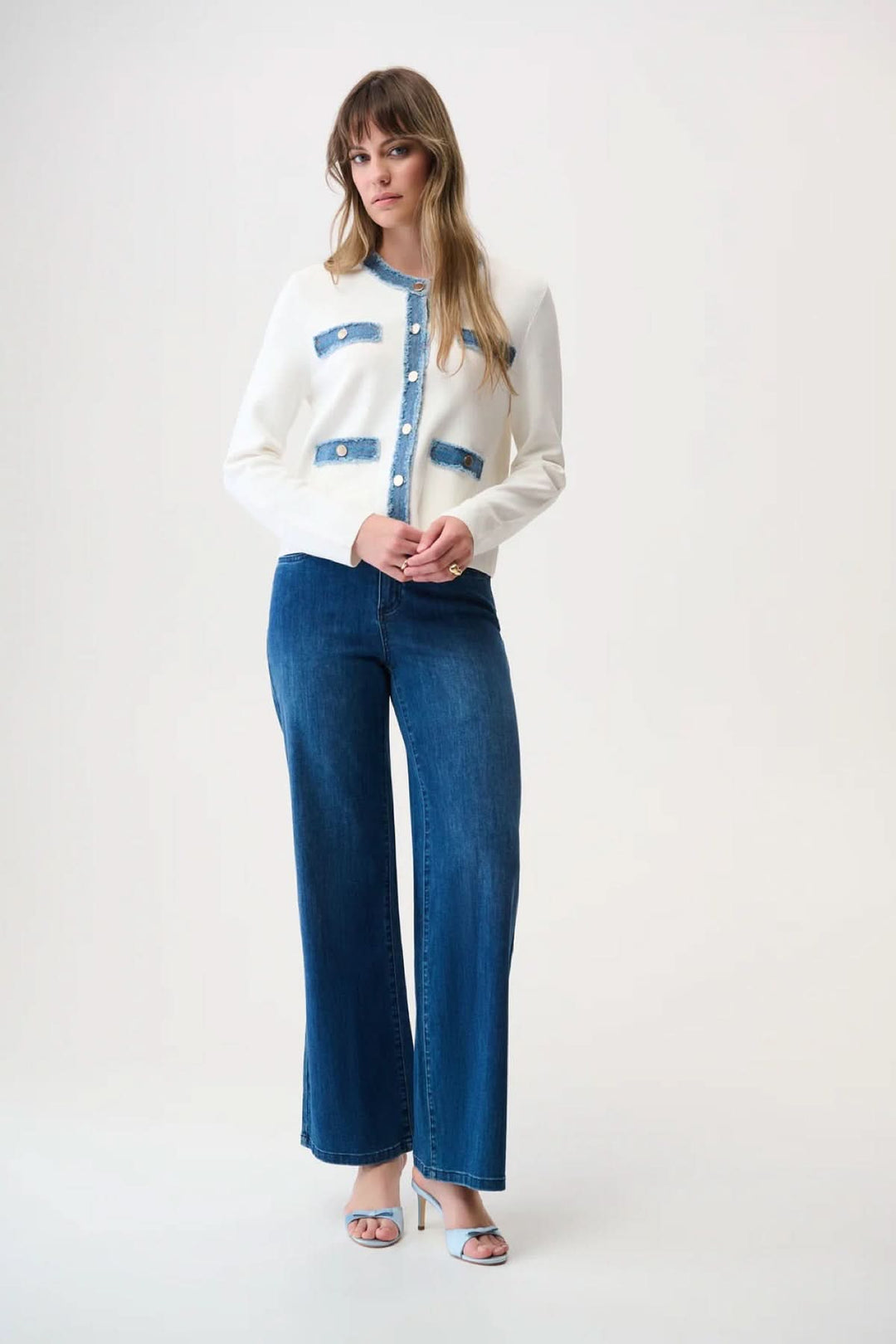 Femme portant un cardigan élégant avec détails denim, boutons argentés, et poches stylées. Description : Cardigan élégant moderne.