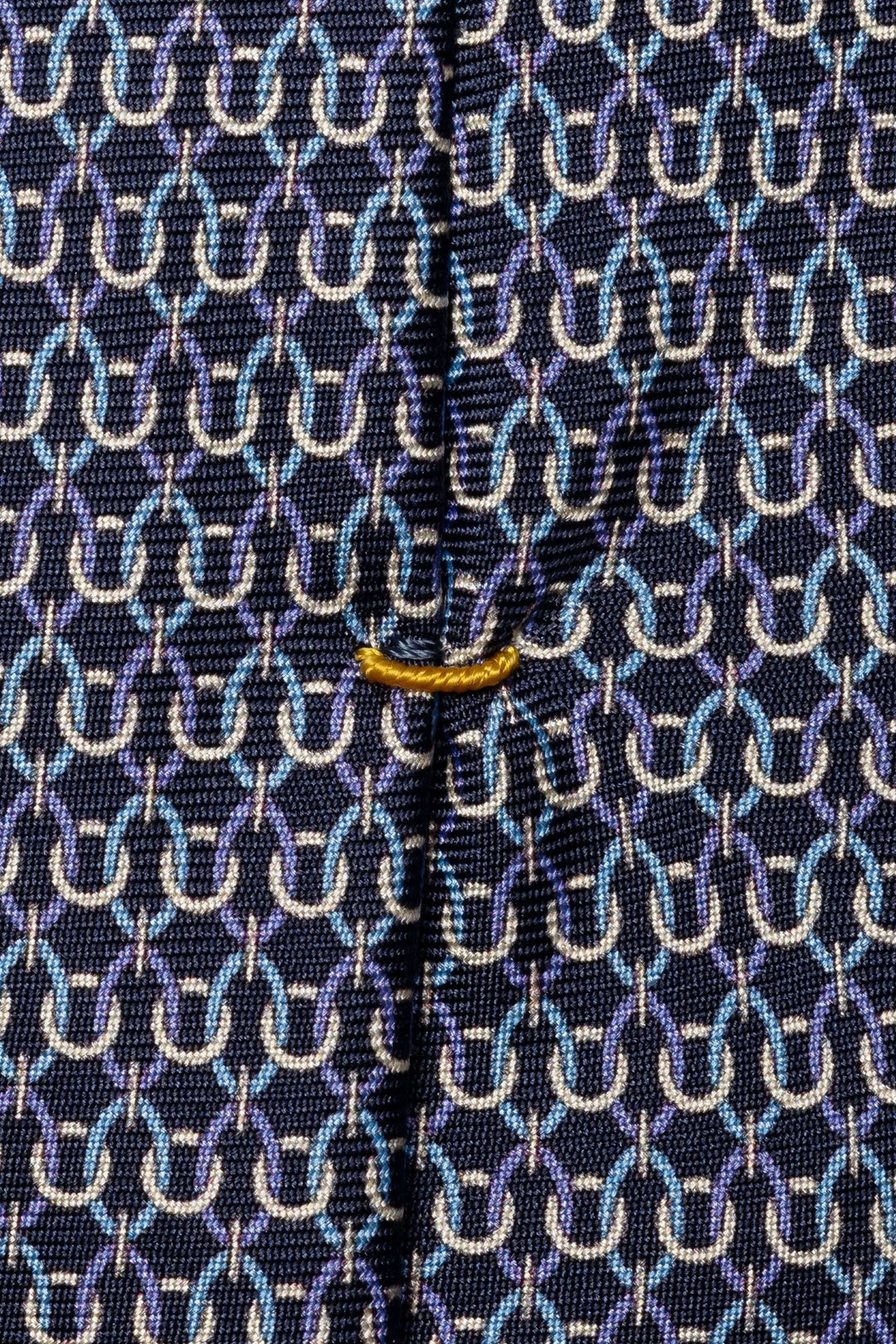 Cravate motif géométrique tissé en nuances de bleu et blanc sur fond foncé, avec finition soyeuse et détails raffinés.