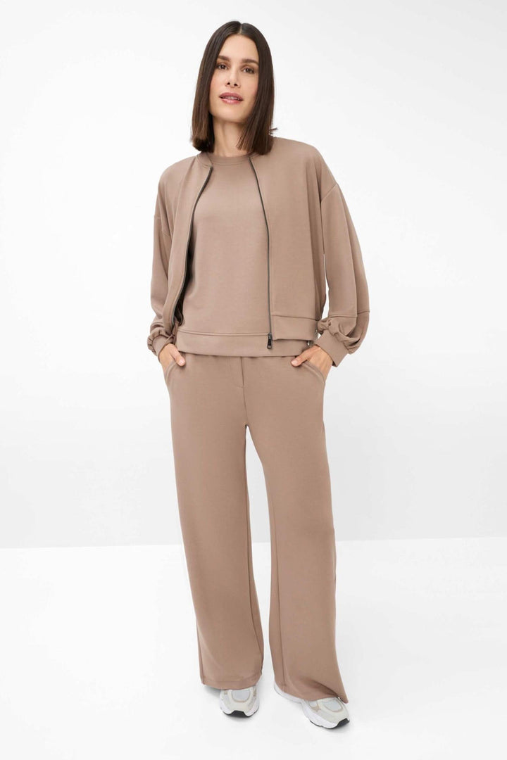 Femme portant un pantalon palazzo Maine beige avec un haut coordonné, style chic-décontracté.