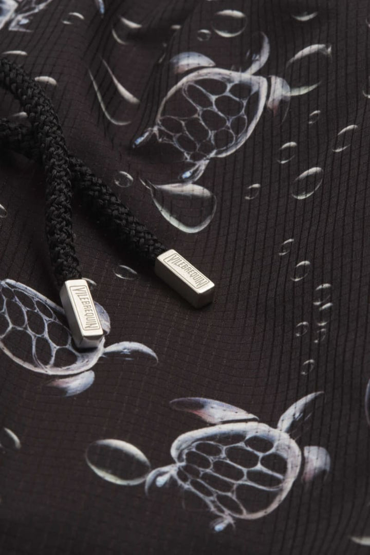 Vue de face maillot de bain à imprimé tortues Vilebrequin pour homme bleu avec détails logo - Valérie Simon