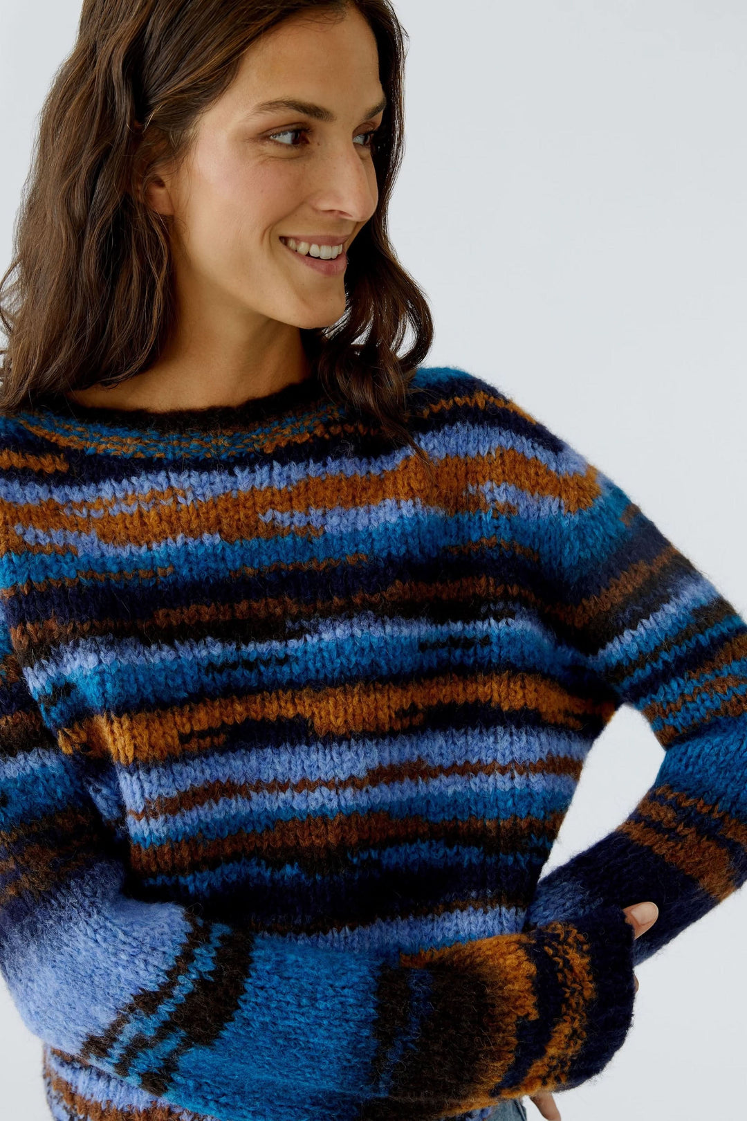 Femme portant un chandail en tricot rayé à col rond, confortable et décontracté, parfait pour la saison froide.