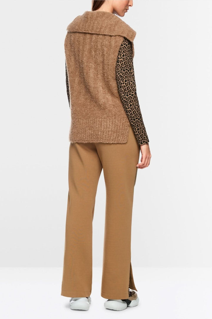 Veste sans manche tricoté en maille douce avec col chemise et design minimaliste, vue arrière sur mannequin portant pantalon beige.