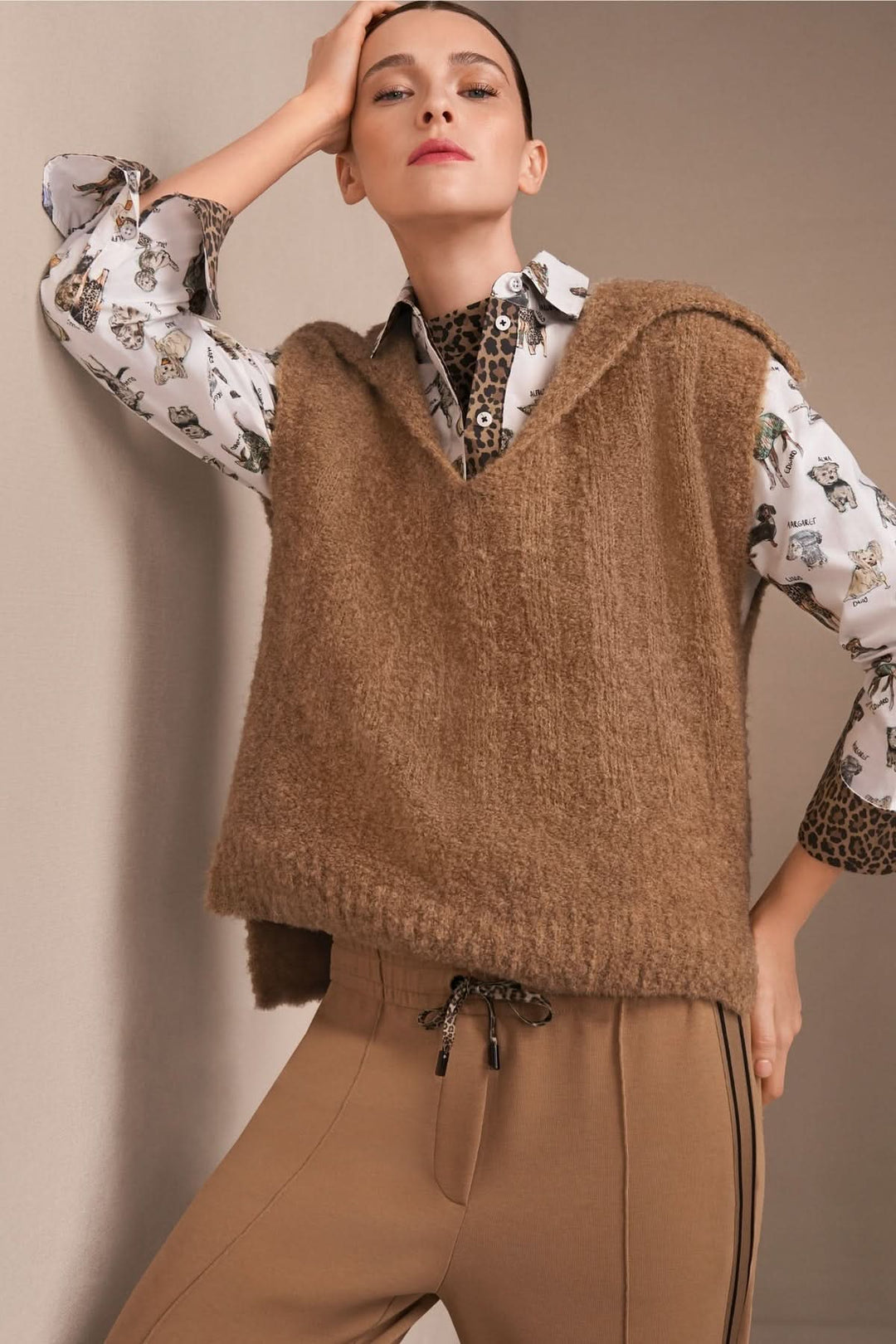 Veste sans manche tricoté avec col chemise et encolure en V, style moderne superposé sur chemise imprimée pour look chaleureux.