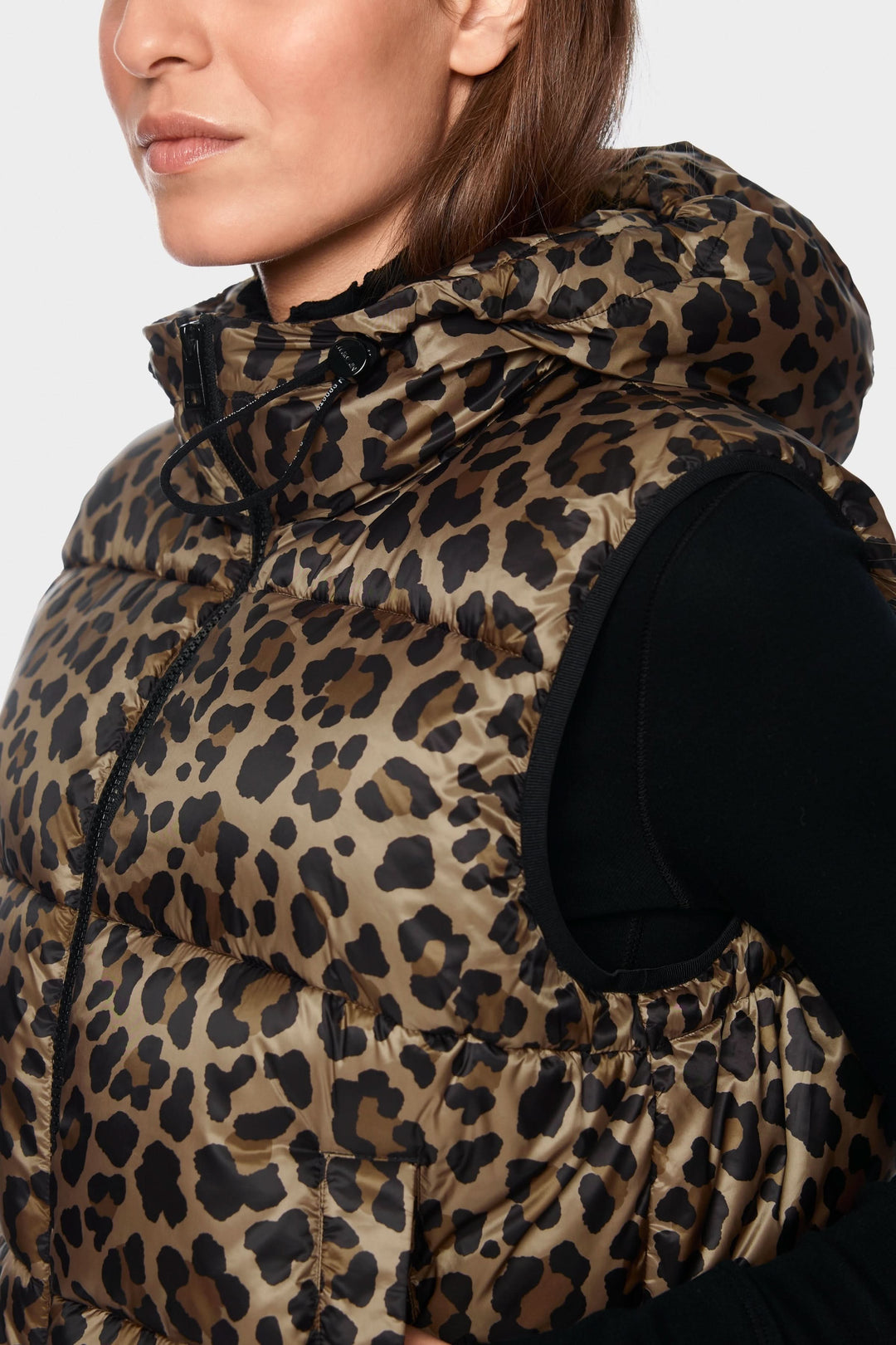 Veste matelassée à imprimé léopard et capuchon portée par une femme, mettant en valeur l'élégance et confort du vêtement.
