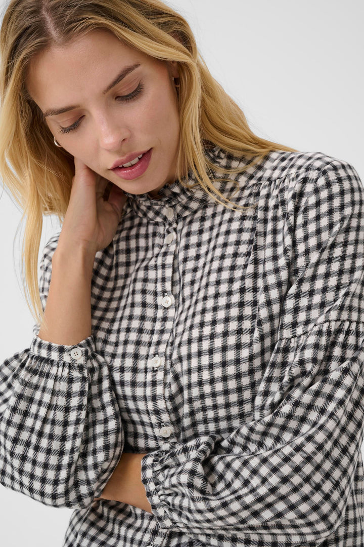Blouse Samilla à carreaux avec col volanté et manches bouffantes, idéale pour un look chic et intemporel.