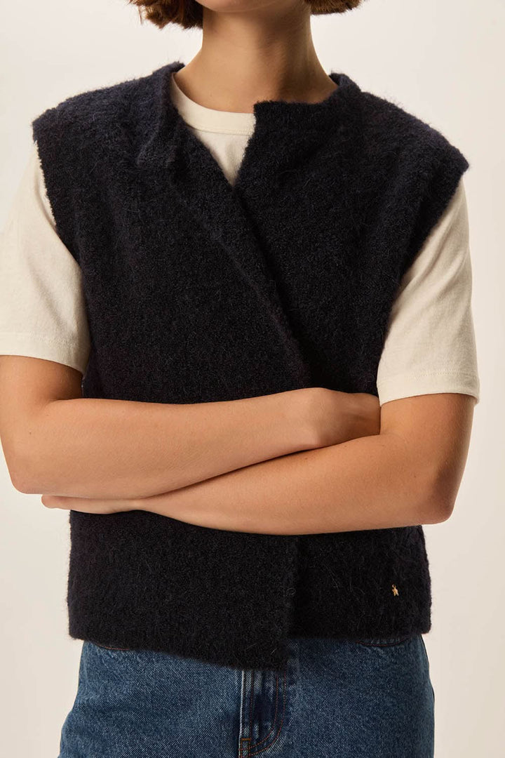 Veste Achille sans manches en laine bouclée portée sur un t-shirt blanc, coupe droite et ample, look décontracté avec jean.