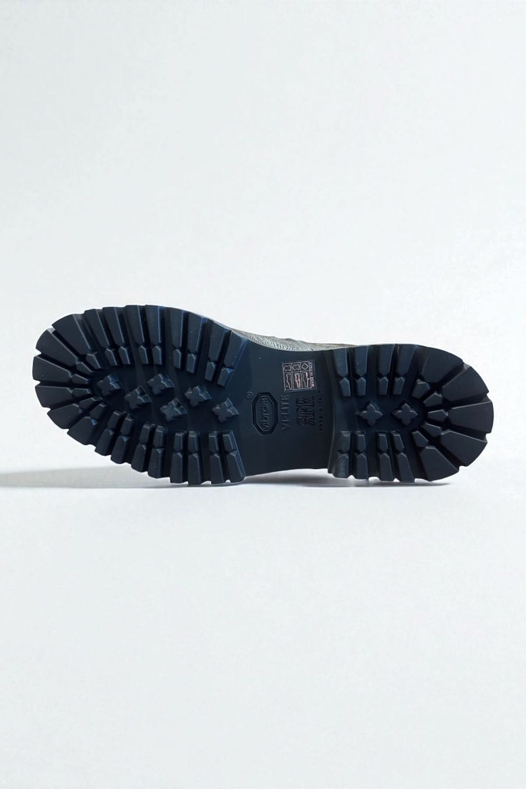 Semelle crantée de bottine homme cuir texturé avec robustesse et élégance italienne, offrant adhérence et confort.