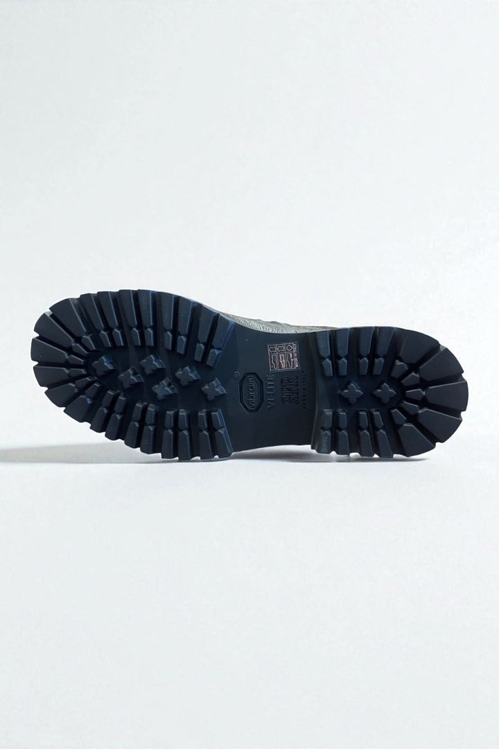 Semelle crantée de bottine homme cuir texturé avec robustesse et élégance italienne, offrant adhérence et confort.