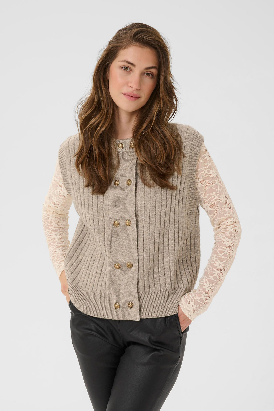Veste Eroka sans manches en tricot à boutons dorés portée par une femme, chic et élégante pour la mi-saison.