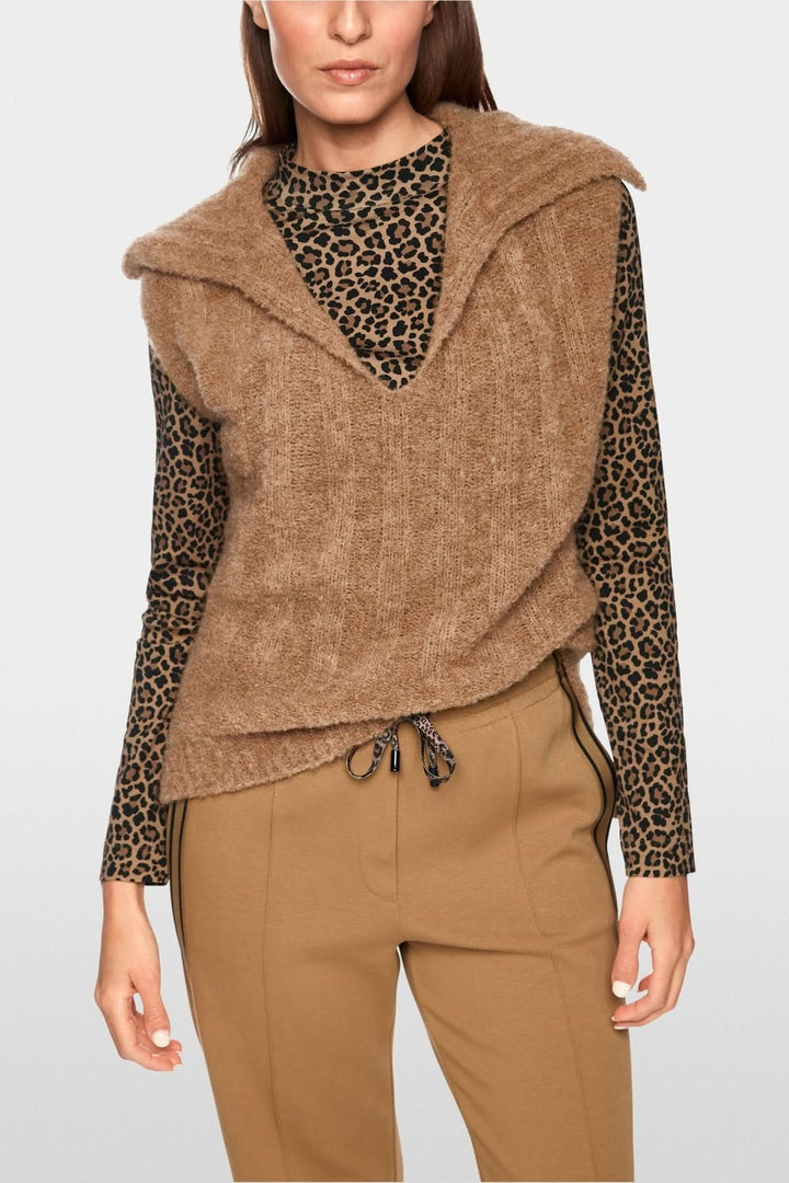 Femme portant une veste sans manche tricoté avec col chemise élégant et encolure en V, idéale pour la superposition moderne.