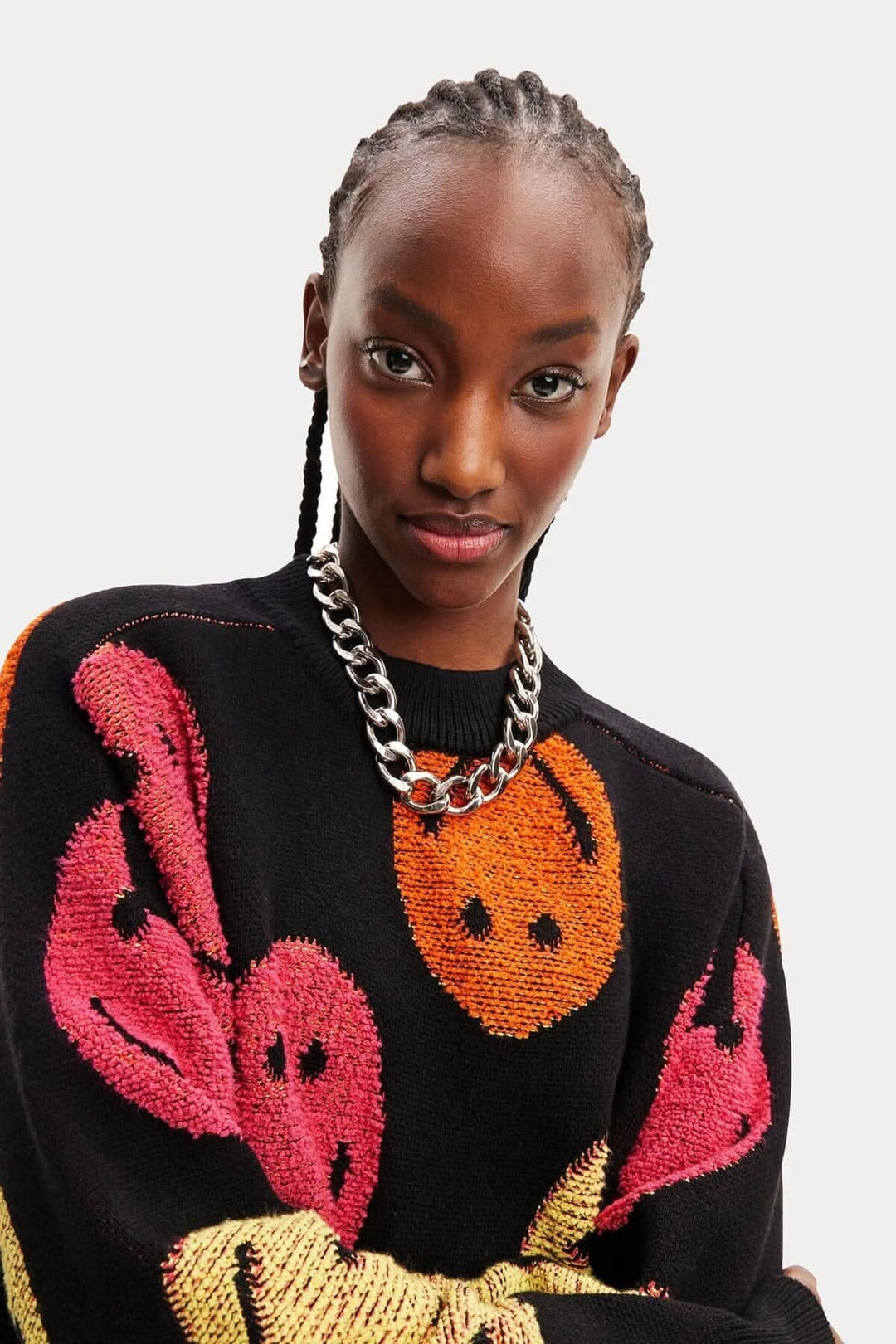 Pull ample à manches longues en grosse maille jacquard avec imprimé couleurs, porté par un modèle élégant.