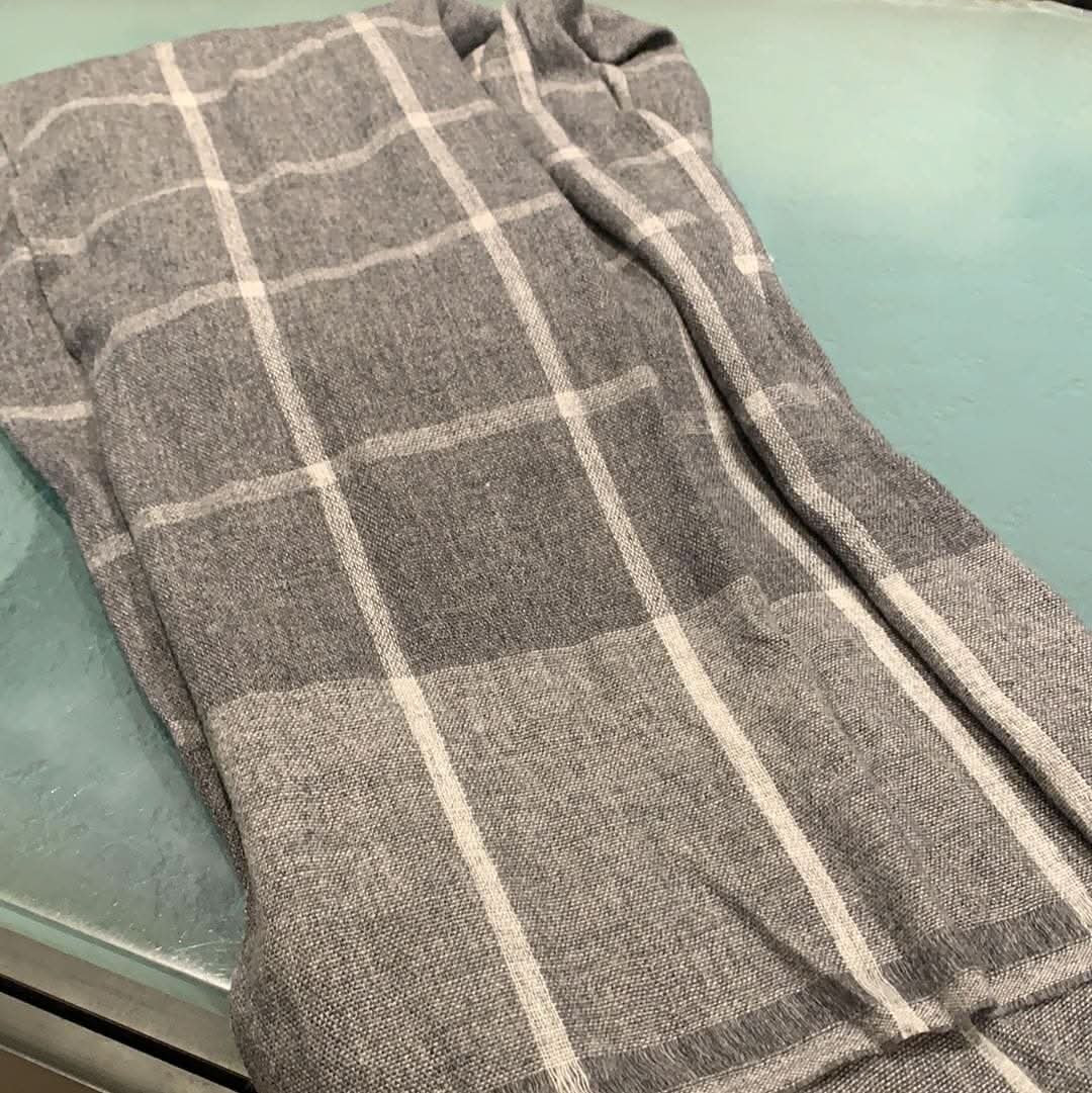 Foulard gris en laine avec motifs à carreaux, étiquette brune LCMER, 100% laine, parfait pour les saisons fraîches.